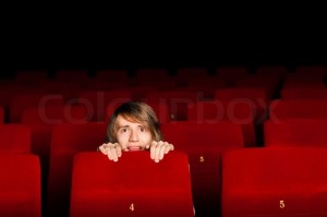 young-man-in-the-cinema-hiding-behind-a-chair